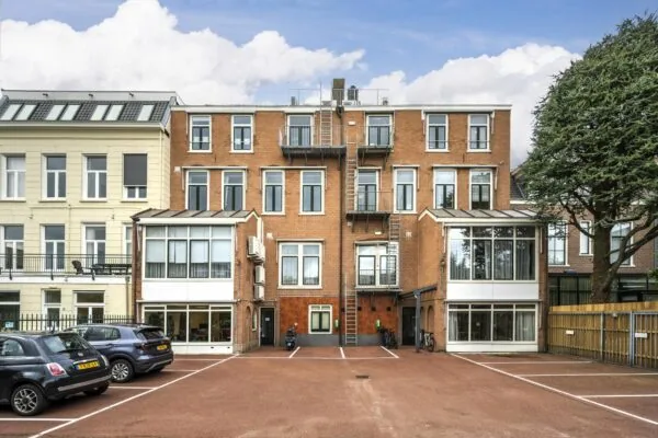 Achterzijde van een kantoorpand aan de Nieuwe Gracht met parkeerplaatsen en fietsenrekken.